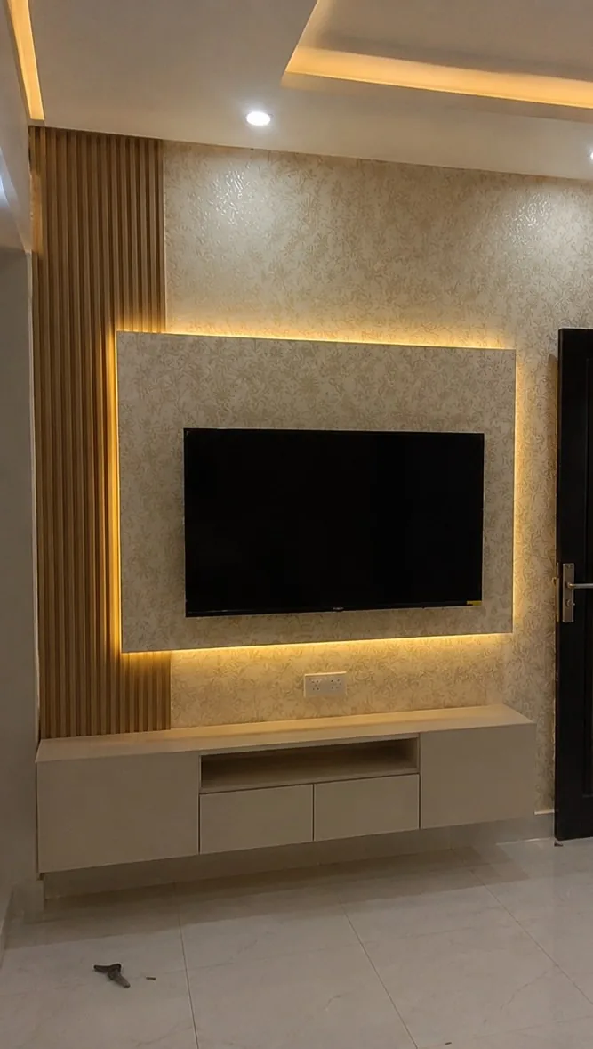 Damask-patterned wallpaper hung across a backlit TV feature wall in a Doha living room