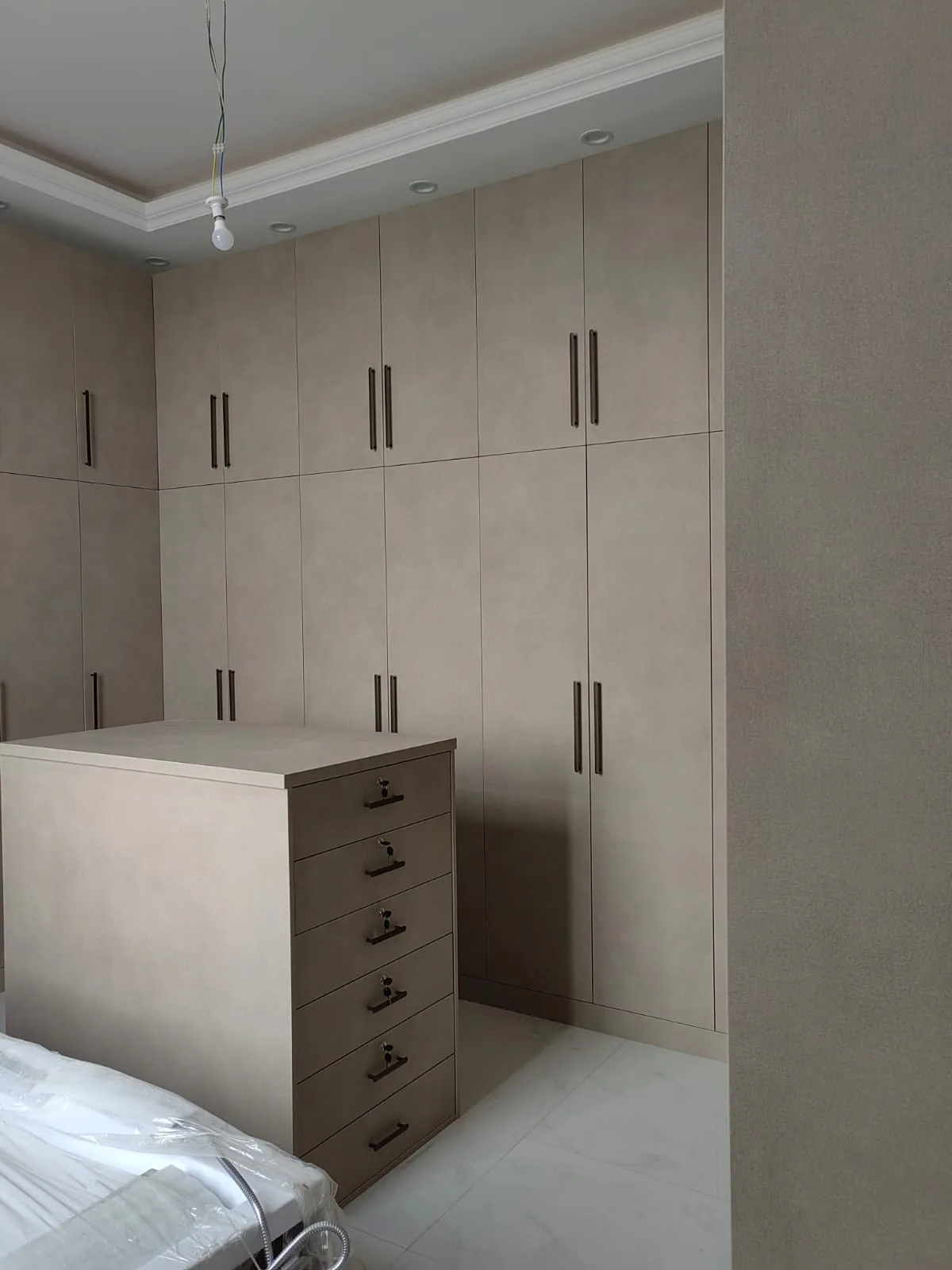 Dressing room fit-out with full-height wardrobes and a central drawer island