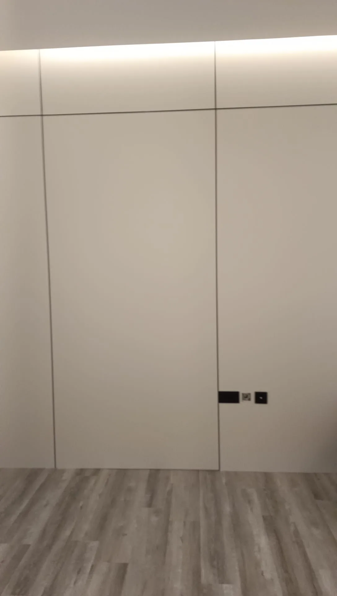 Detail of a handleless wardrobe finished flush with the wall and ceiling